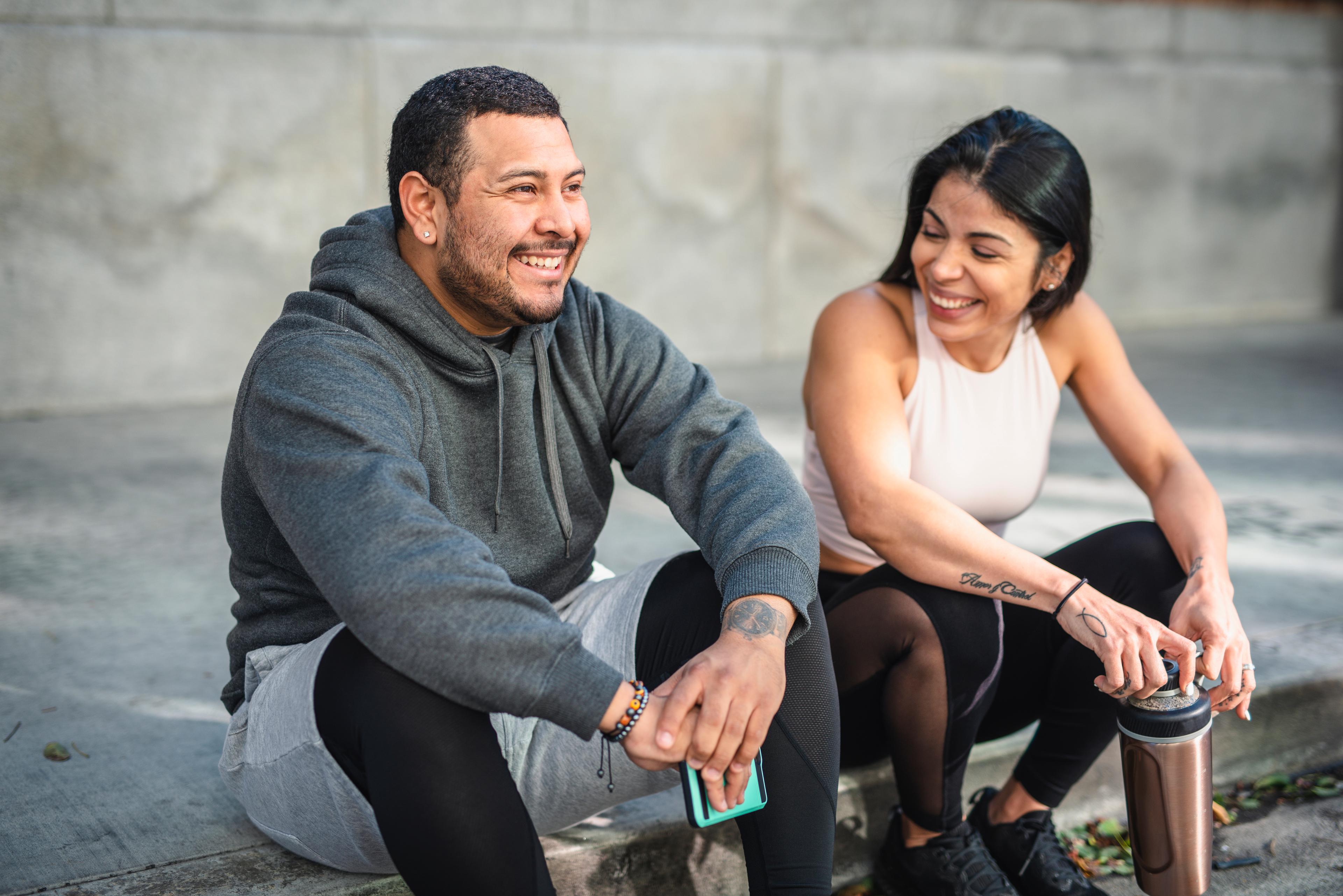 friends laughing on street curb