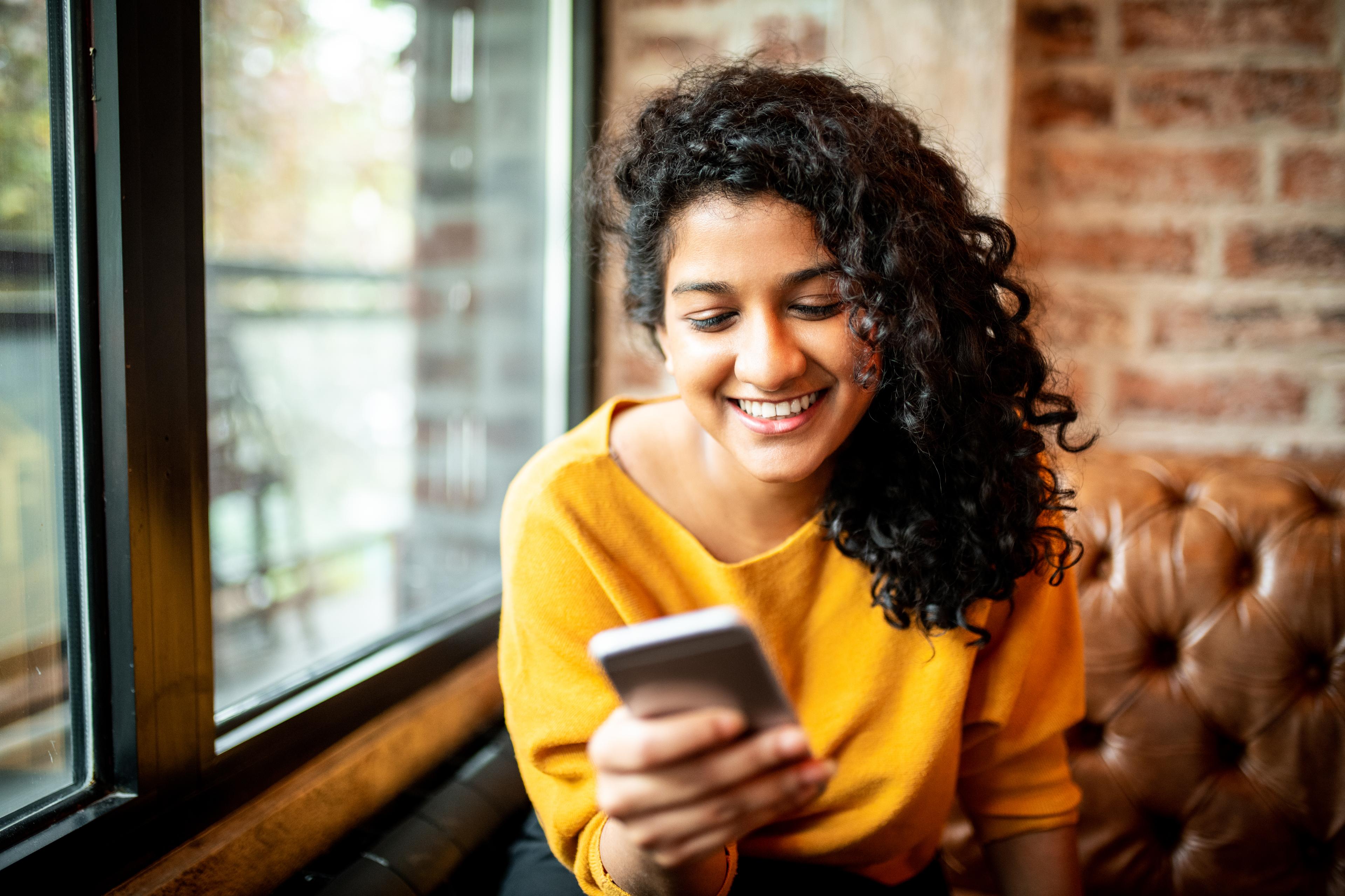 woman smiling at smartphone