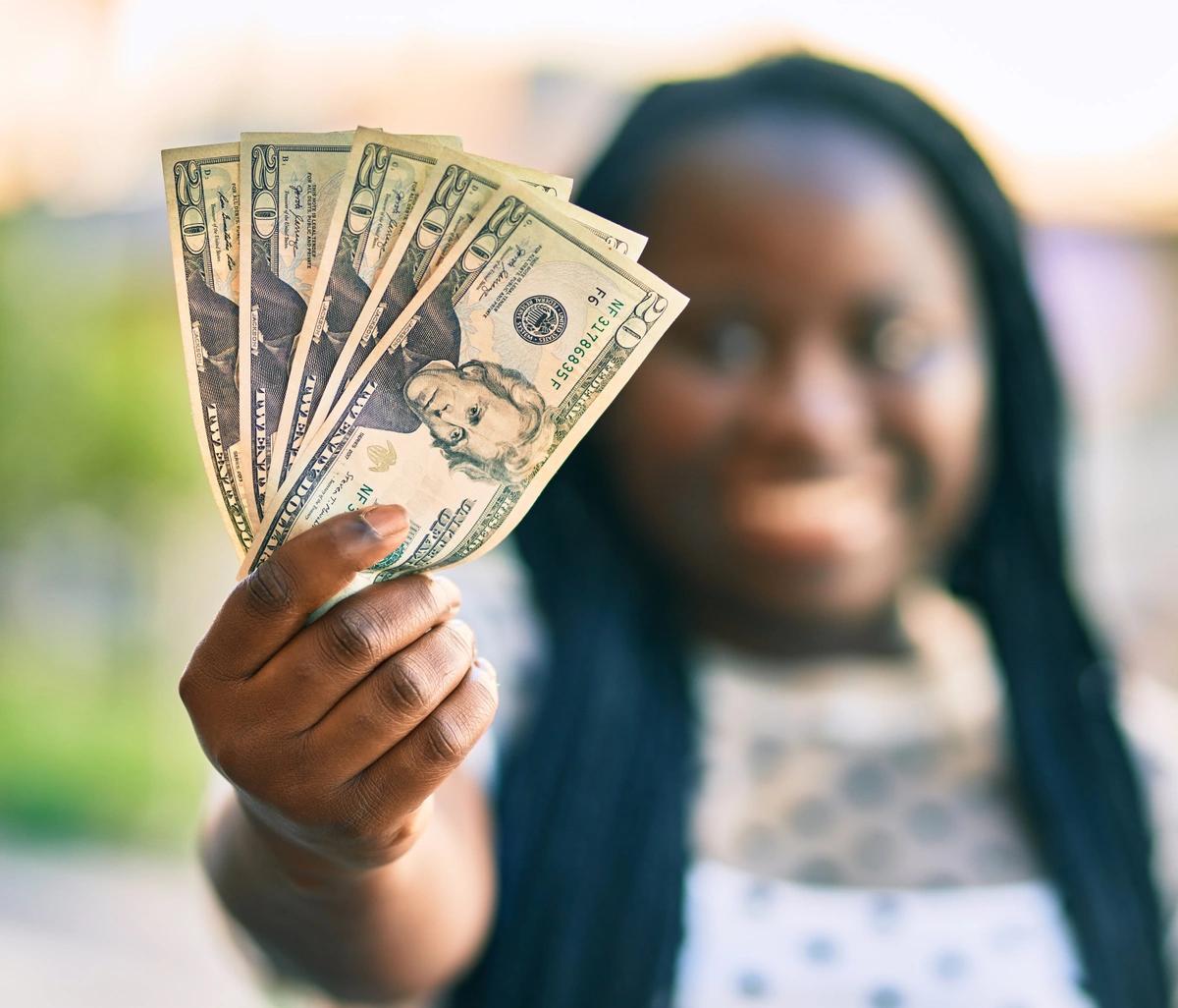 Easy 100 woman holding $20 bills