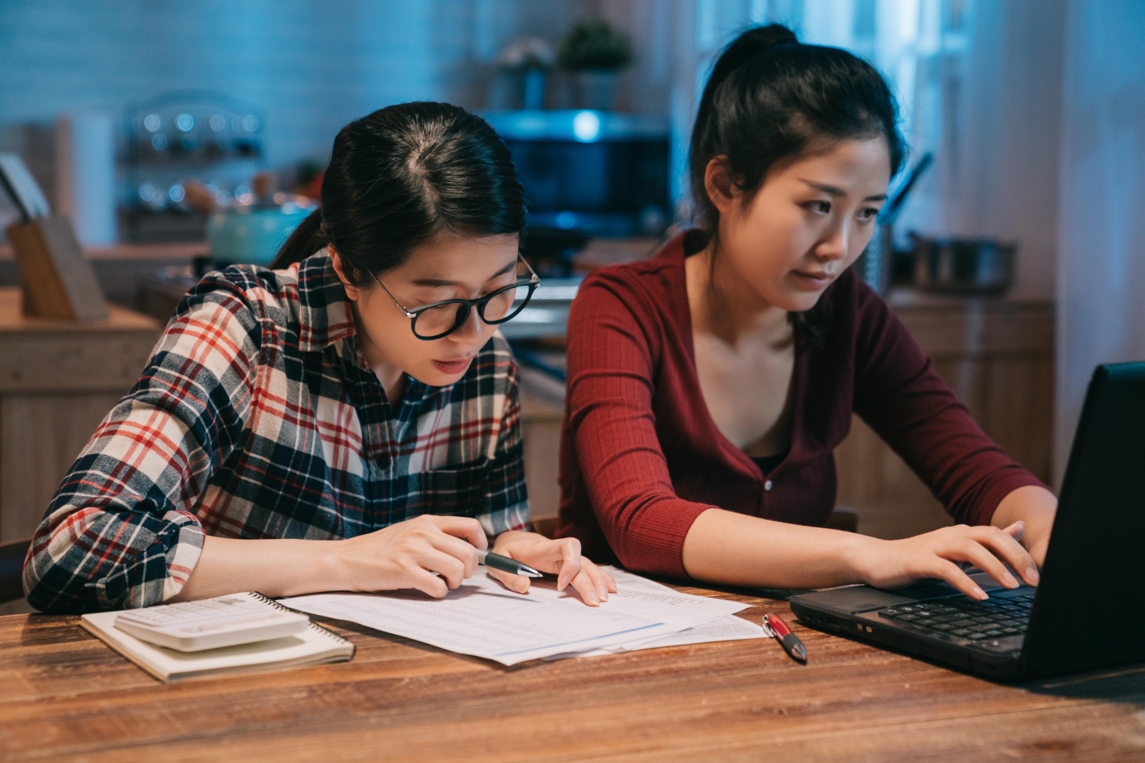 two women working on taxes on a laptop