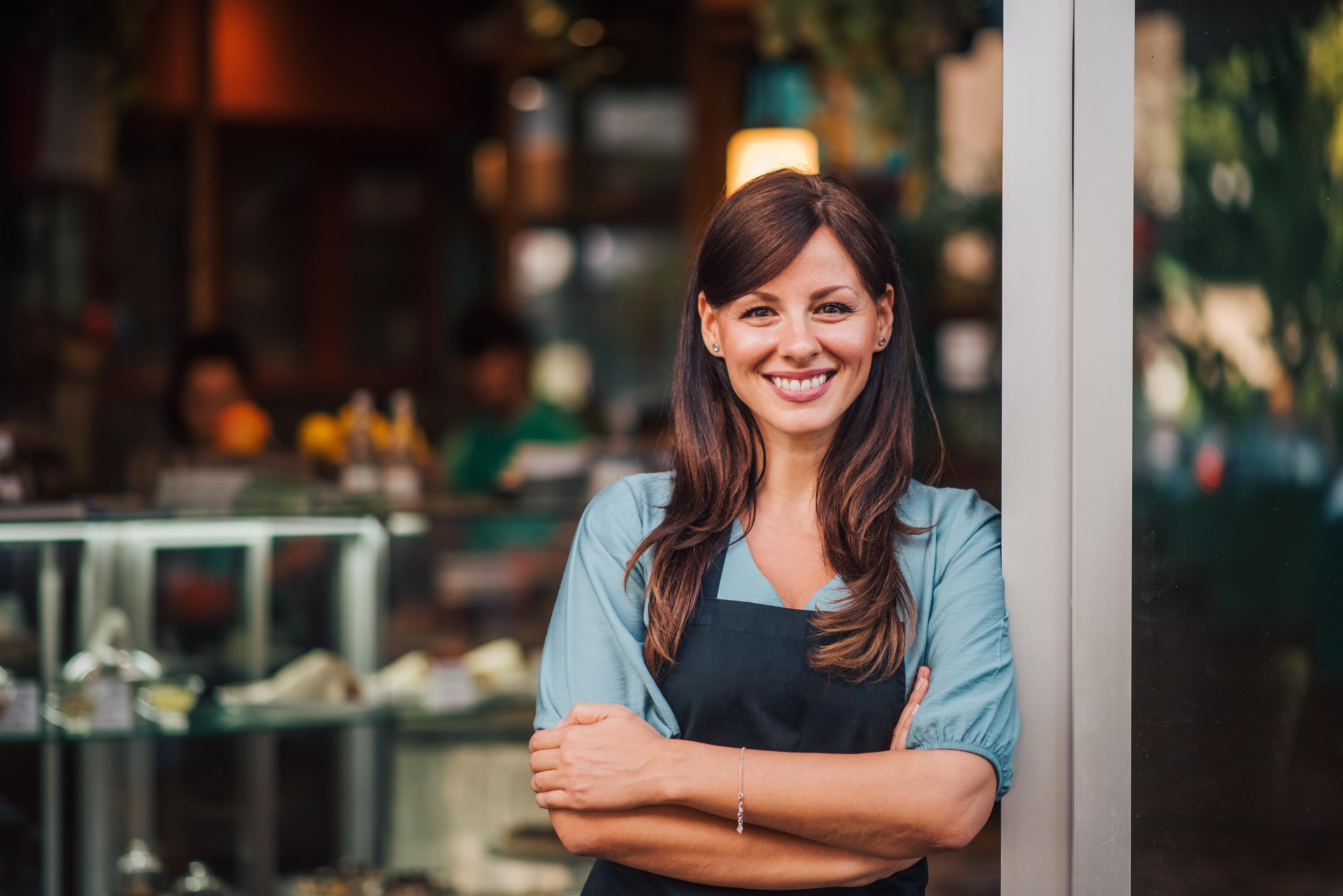 woman standing in doorway of her business